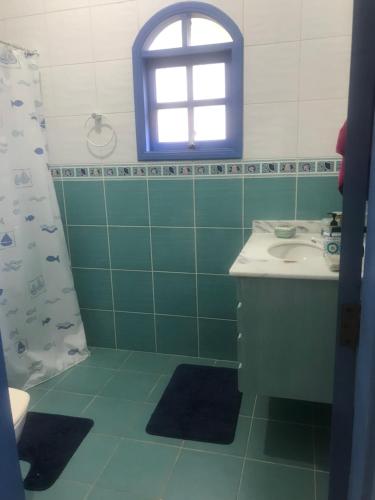 une salle de bain avec un lavabo et une fenêtre dans l'établissement Casa beira mar Angra dos Reis, à Angra dos Reis