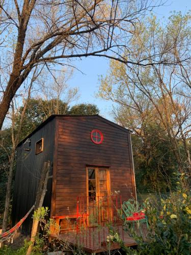 a small cabin in the woods with a red window at Danan - Cabañas granero en Andino in Andino