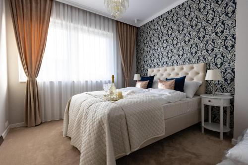 a bedroom with a large white bed with a window at Apartment LUXOR - Airport Katowice-Pyrzowice in Bobrowniki