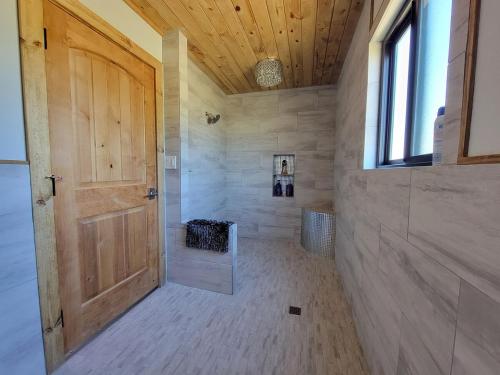 Un baño grande con puerta de madera y ventana. en Private Retreat with Pond, Pool and Hot Tub, en Boyd