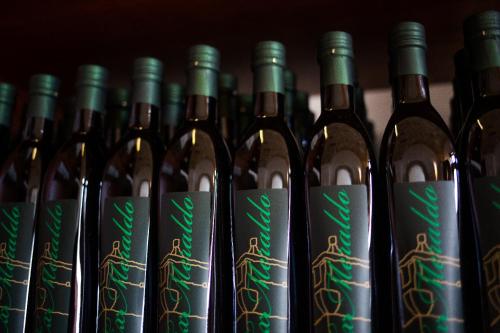a row of wine bottles lined up in a row at Masseria Stali, The Originals Relais in Caprarica di Lecce