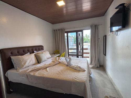 a bedroom with a bed with a television on the wall at Pousada Solare in Maragogi