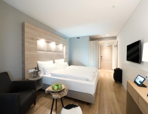 a bedroom with a large white bed and a couch at WONNEMAR Resort-Hotel in Wismar