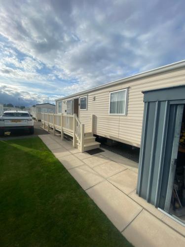 an rv parked in a yard next to a car at Lisa caravan hire 
