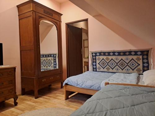 a bedroom with a bed and a dresser and a mirror at Ropuszy Dwór in Żerdenka