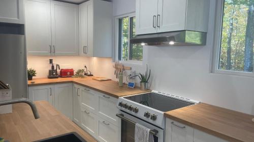 a kitchen with white cabinets and a sink and a stove at Maison de vacances à l'Ile d'Orleans in St-Pierre-de-l'Île-d'Orléans