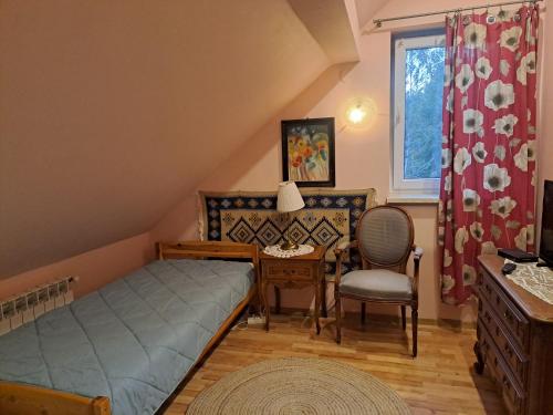 a bedroom with a bed and a desk and a chair at Ropuszy Dwór in Żerdenka