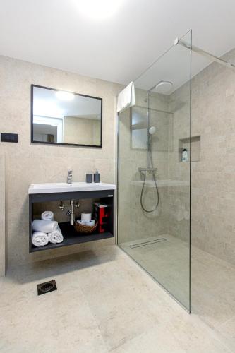 a bathroom with a shower and a sink and a mirror at Villa Mare Private Stone Villa with Heated Pool and Garden in Vinišće