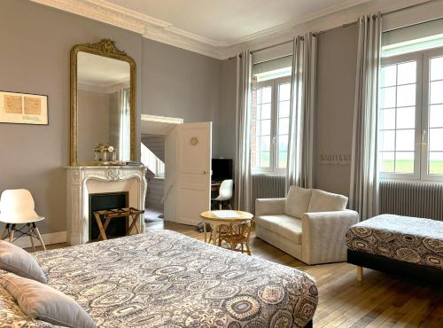 a bedroom with a bed and a mirror and a chair at Ferme De Bonavis in Banteux