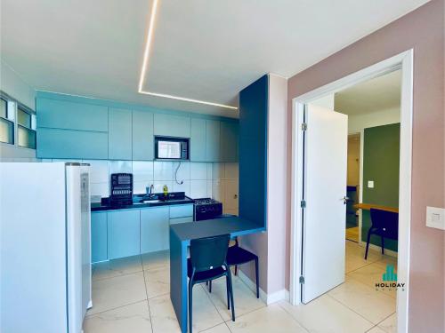 a blue kitchen with a table and a refrigerator at Aquarius Style by Holiday Stays in Fortaleza