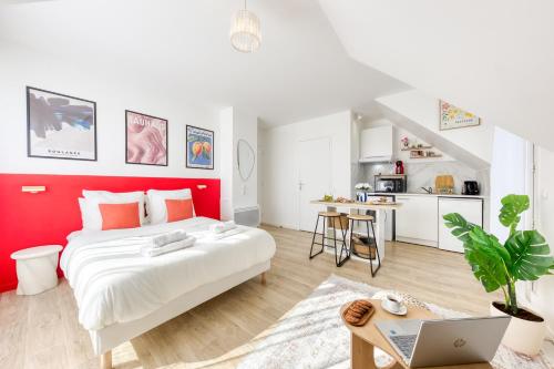 a white and red bedroom with a bed and a laptop at Suite Bauhaus - Proche Paris - Terrasse - Netflix in Bobigny