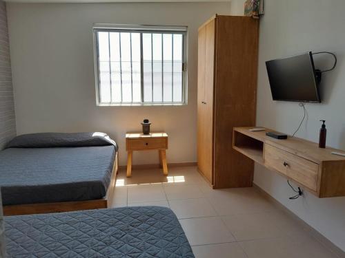 een slaapkamer met een bed en een televisie en een tafel bij Casa para toda la familia o amigos Zona Industrial Monterrey in Monterrey