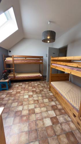 a room with three bunk beds and a tiled floor at La Grange Blanche in Saint-Germain