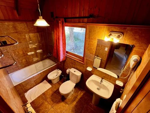 a bathroom with a toilet and a sink and a tub at Cabañas Pista Uno Ski Village - Cerro Chapelco in San Martín de los Andes