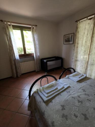 a bedroom with a bed with two chairs and a window at Vacanza nel boschetto in Narni