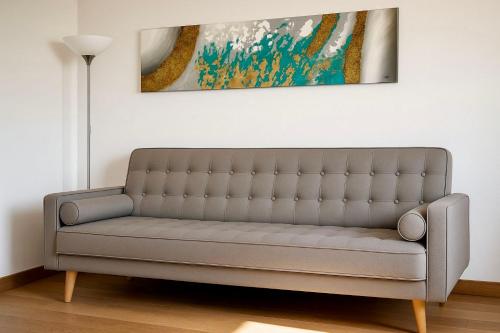a couch in a living room with a painting on the wall at Villa La Gioconda in Arezzo