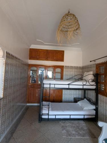 1 Schlafzimmer mit 2 Etagenbetten und einem Kronleuchter in der Unterkunft Appartement City Center in Ouarzazate