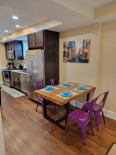 a kitchen with a wooden table and purple chairs at Luxurious DC Townhome ideal for Large Families plus Free Parking in Washington, D.C.