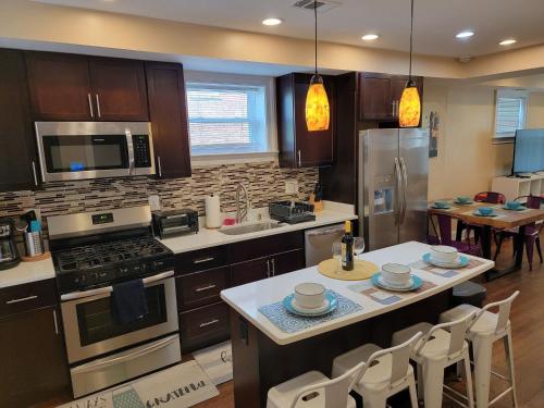 a kitchen with a stove and a counter with chairs at Luxurious DC Townhome ideal for Large Families plus Free Parking in Washington, D.C.