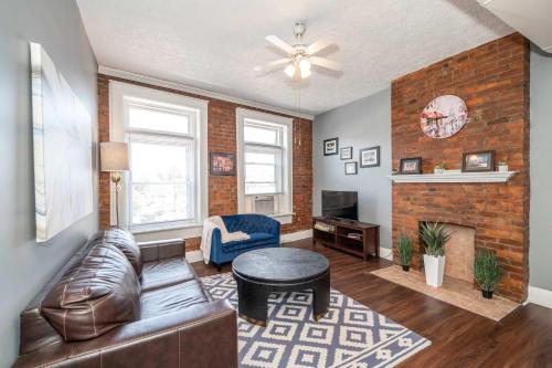 a living room with a leather couch and a fireplace at New Monmouth Loft 1 - City Chic 1 BDR in Newport