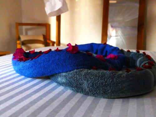 a blue blanket is laying on a bed at Palm House&Restaurant in Utende