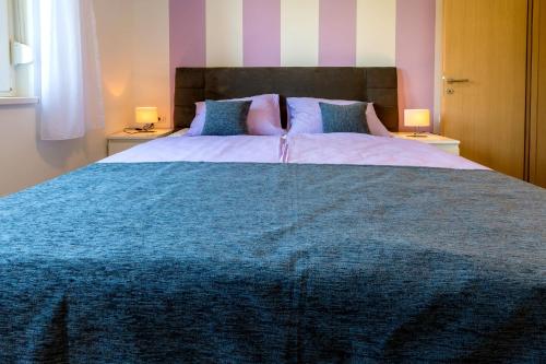 a bedroom with a large bed with a blue blanket at Villa Veronika in Omiš