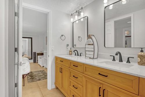 a bathroom with a sink and a mirror at Comfort by the Beach - Heated Pool & Private Beach in Cape Canaveral