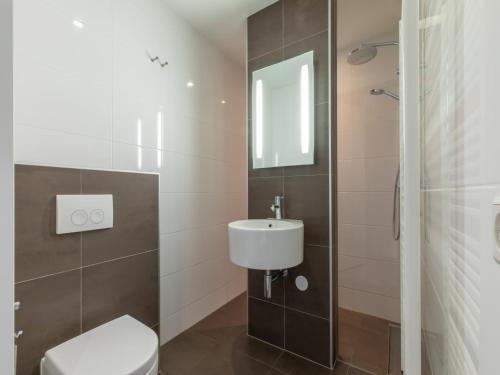 a bathroom with a toilet and a sink at Wifi and golden beaches Home in Zoutelande