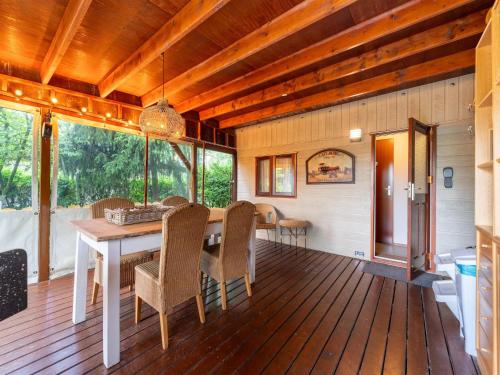 a dining room with a table and chairs on a wooden floor at Chalet in Stegeren near Forest and Pond in Stegeren