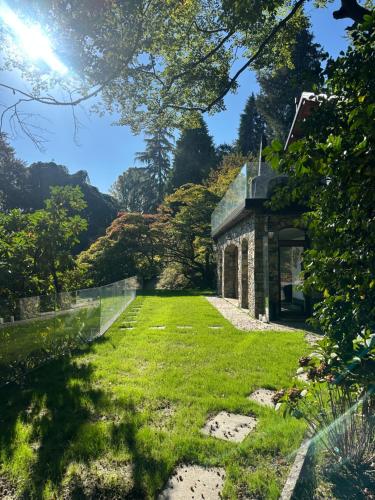 an old stone house with a grass yard at Private Luxury Spa & Silence Retreat with Spectacular View over the Lake Maggiore in Stresa