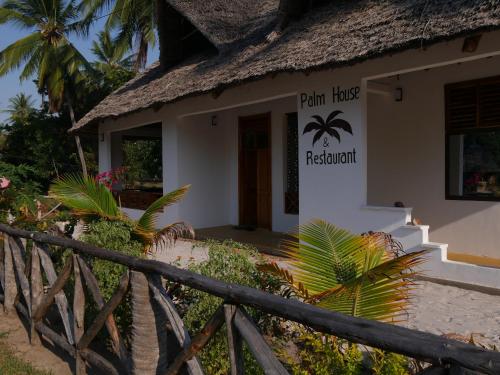 een gebouw met een bord waarop staat 'plant house restaurant' bij Palm House&Restaurant in Utende