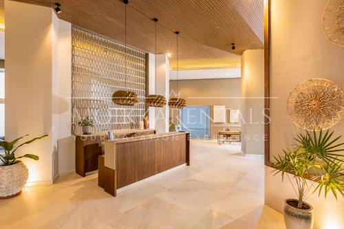 a lobby with a reception desk and potted plants at Harbor NT507 by Moikkarentals in Puerto Vallarta