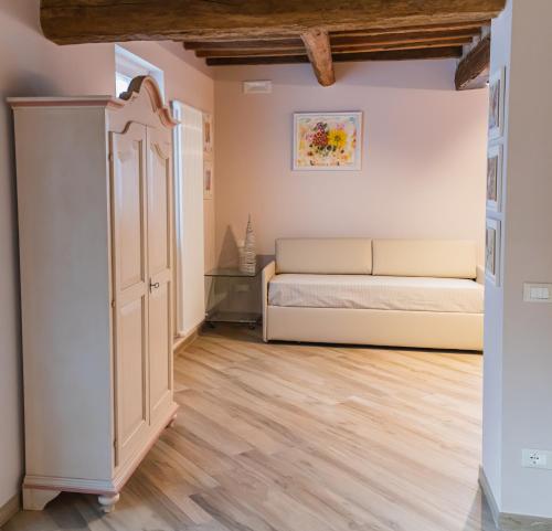a living room with a couch and wooden floors at I Gelsi di San Bernardino Apartment in Fiorenzuola dʼArda