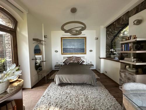 a bedroom with a bed and a chandelier at Private Luxury Spa & Silence Retreat with Spectacular View over the Lake Maggiore in Stresa
