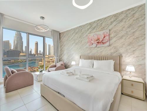 a bedroom with a large bed and a large window at Panoramic Burj 5br Condo with Full Led & Fountain View in Dubai