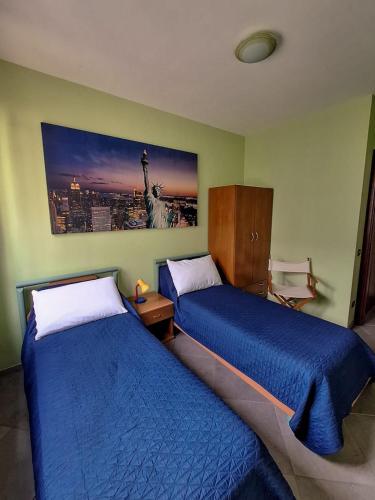 a bedroom with two beds and a picture of the statue of liberty at Lago Maggiore Gardens Apartment in Intra