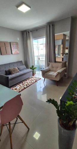 a living room with a couch and a chair and a table at Acomodação Quartzo Rosa - Apartamento Completo in Palhoça