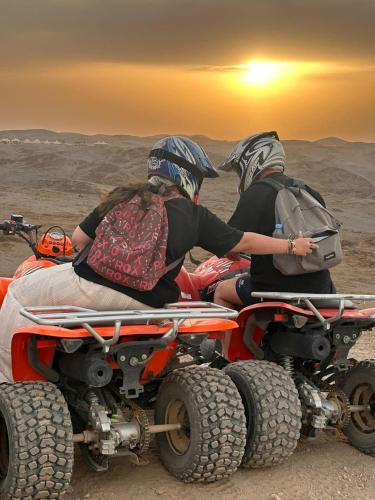 two people sitting on a four wheeler in the desert at Agafay désert excursions tours in El Karia