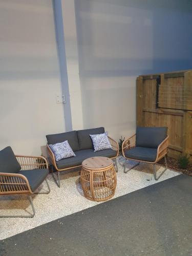 a group of chairs and a couch and a table at Luxury 2 Bed 2 Bath Townhouse Central Christchurch in Christchurch