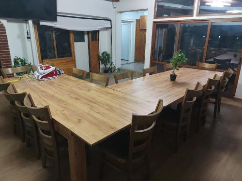 Una gran mesa de madera y sillas en una habitación. en Къща за гости Бела, en Targóvishte