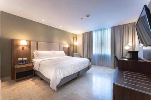 a hotel room with a bed and a flat screen tv at Holiday Inn - Villahermosa Aeropuerto by IHG in Villahermosa