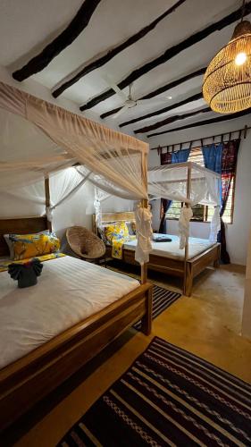 a bedroom with two bunk beds and a ceiling at Palm House&Restaurant in Utende
