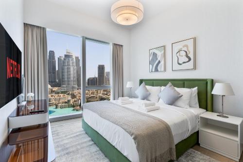 a bedroom with a large bed and a large window at 2Bed with spectacular Burj Khalifa & fountain view in Dubai