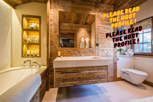 a bathroom with a tub and a sink and a toilet at Luxuriöses Zermatt Chalet mit Pool & Jacuzzi in Zermatt
