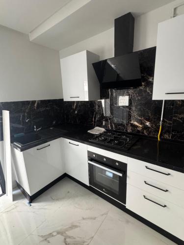 a kitchen with white cabinets and a stove top oven at Jawharet karam in El Aouina Station