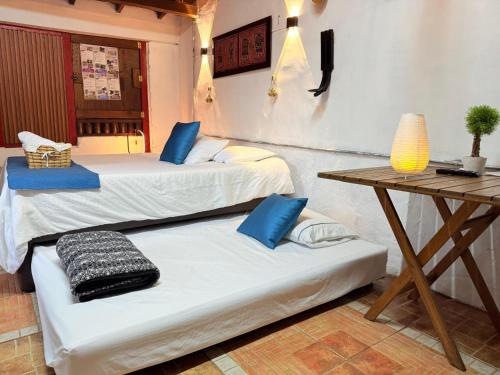 two beds in a room with a wooden table at Cabaña & glamping para grupos de 4 a 6 personas, cerca al parque y con avistamiento de aves in Jardin