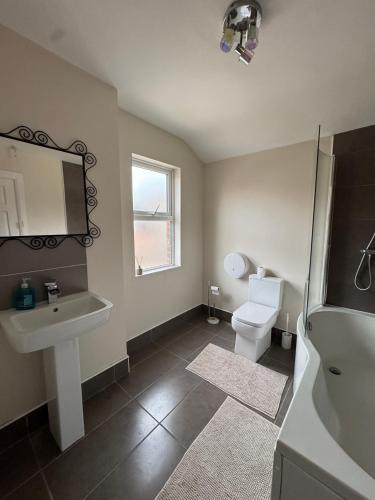 un baño con lavabo e inodoro en Cozy House Great Location, en Belfast