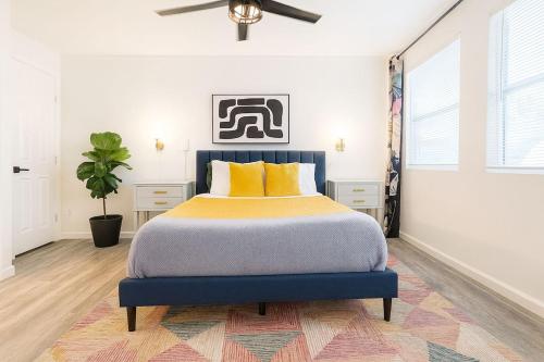 a bedroom with a king sized bed with yellow pillows at Golden Girls Home at Dtwn, Fenced Yard, Sleep 9 in Austin