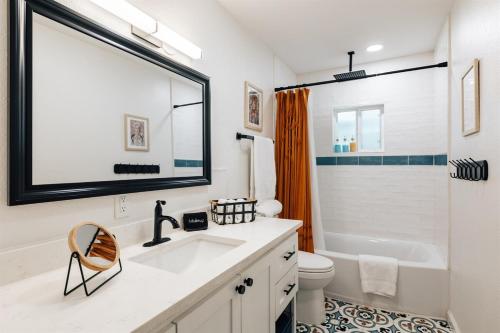 a bathroom with a sink and a tub and a toilet at Golden Girls Home at Dtwn, Fenced Yard, Sleep 9 in Austin