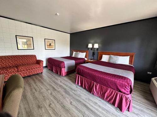 a hotel room with two beds and a couch at Skyview Motel - Prairie du Sac in Prairie du Sac